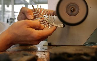Using a series of grinding torches and ever thinner sandpaper, the jeweller works the material to bring out its full lustre and all the brilliance of  gold jewellery.